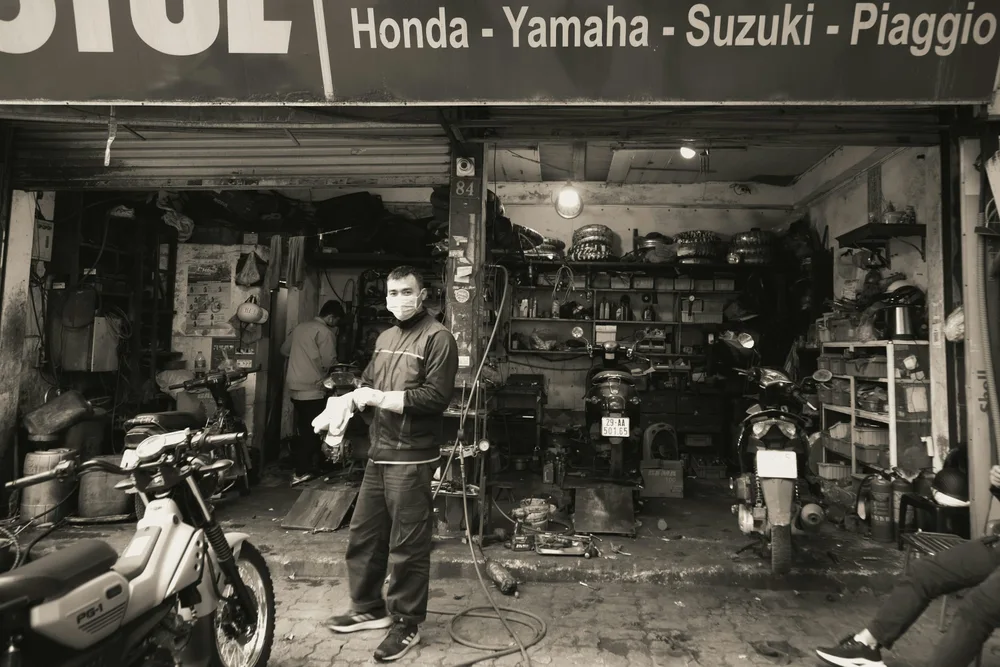 Motorcycles, tools and workers inside a repair shop in Hanoi. Illustrative photo.